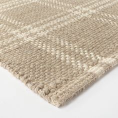 an area rug with white and beige colors on top of the carpet, it is made out of thick yarn