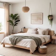 a bedroom with a bed, plant and pictures on the wall