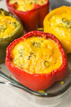 three stuffed peppers sitting on top of a pan with cheese and seasoning in them