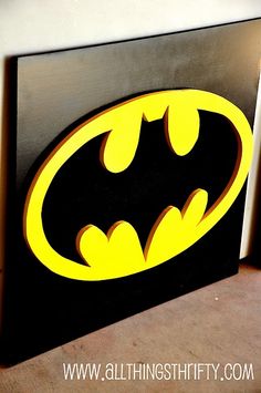 the batman symbol is painted on a black and yellow box with white lettering that says,