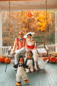 three people in costumes sitting on a porch swing with two children dressed up as clowns