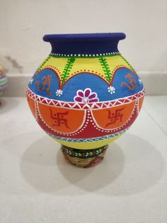 a colorful vase sitting on top of a white table next to other items and decorations