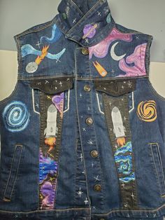 a denim vest with patches on the front and back, decorated with images of space shuttles