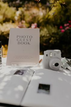 an open photo book sitting on top of a table next to a camera and glasses