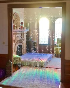 the bedroom is decorated in rainbow colors and has a large window with curtains on it