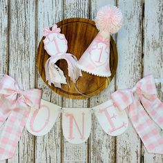 a pink and white baby shower set on a wooden platter