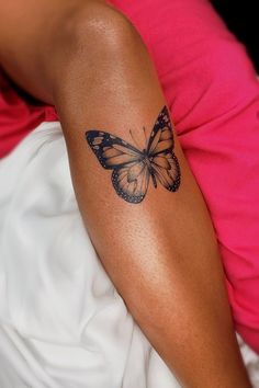 a woman's arm with a butterfly tattoo on the left side of her arm