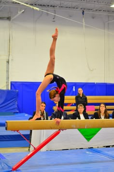 a person on a balance beam doing a handstand