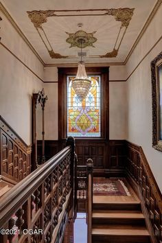 an ornate staircase with stained glass window and wooden handrails