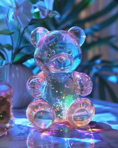 a clear teddy bear sitting on top of a table next to a vase filled with flowers