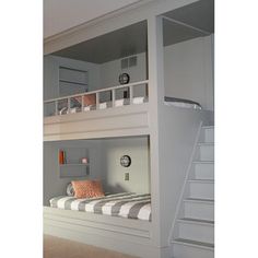 a bunk bed sitting in the middle of a room next to a stair case and window