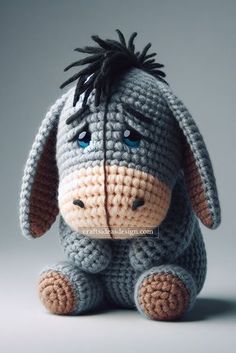 a crocheted stuffed animal sitting on top of a white table next to a gray wall