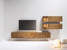 an entertainment center with shelves and a flat screen tv mounted on it's wall