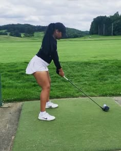 a woman is playing golf on the green