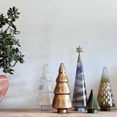 a group of small christmas trees sitting on top of a wooden table