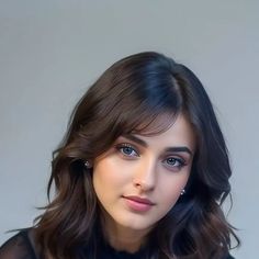 a close up of a person wearing a black shirt and blue eyeshadow with long wavy hair