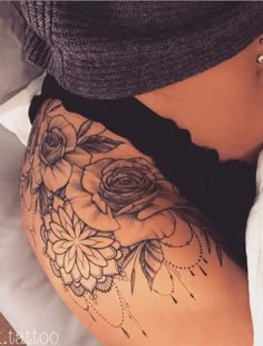 a woman's stomach with tattoos on it and flowers in the middle of her belly