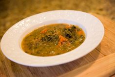 a white bowl filled with soup on top of a wooden table