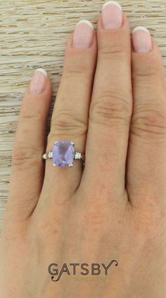 a woman's hand with a ring on it and an amethorate stone