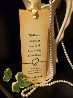 a bookmark with pearls attached to it on a table next to a leaf and bead necklace