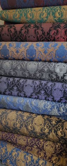 a stack of different colored fabrics on top of each other in various sizes and colors