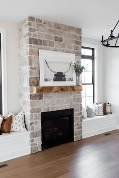 a living room with a brick fireplace and two windows