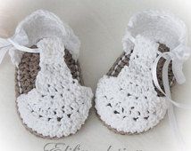 two crocheted baby shoes with bows on them