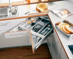 an open drawer in the middle of a kitchen