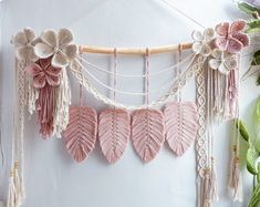 a wall hanging with pink leaves and flowers