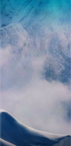 an airplane is flying through the clouds over mountains