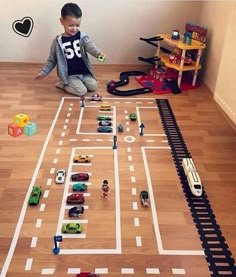 a toddler playing with toy cars on the floor in his playroom at home