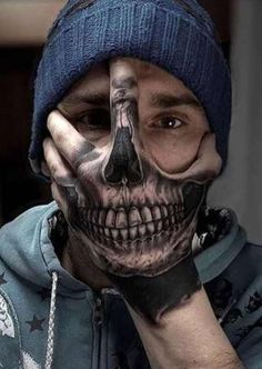 a man with his face painted to look like he is holding his hand up to his face