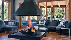 a living room filled with furniture and a fire pit in the middle of it's center