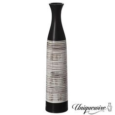 a tall black and white vase sitting on top of a table