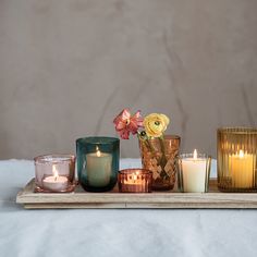 candles and flowers on a wooden tray