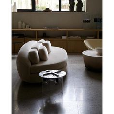 a living room filled with furniture and large windows