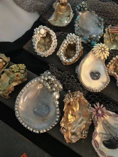 there are many different types of shells on the table with pearls and beads in them