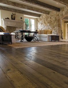 a living room with wood floors and stone walls