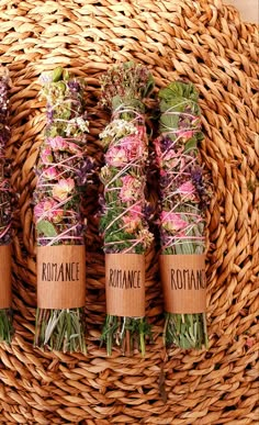 four bundles of dried flowers sitting on top of a wicker basket