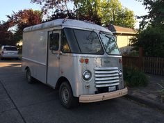 an old food truck is parked on the side of the road in front of a house