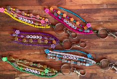 several different colored beads and key chains on a wooden floor