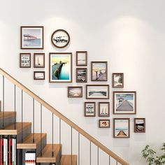 there are many framed pictures on the wall next to the stair case and bookshelf