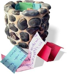 a vase made out of rocks with notes attached to it