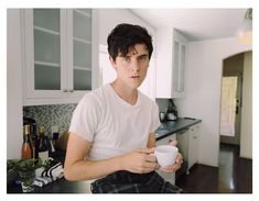 a young man holding a cup in his hands