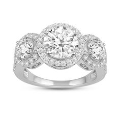 three stone engagement ring with round diamonds on the shoulders and sides, set in 18k white gold