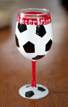 a wine glass with a soccer ball painted on it