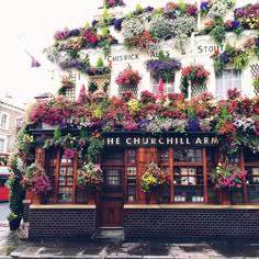 a building covered in lots of flowers and plants