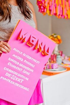 a woman holding up a pink menu sign