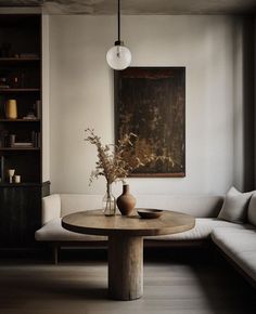 a living room filled with furniture and a painting hanging on the wall above a table