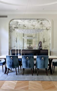 an instagramted photo of a dining room with blue chairs and a chandelier